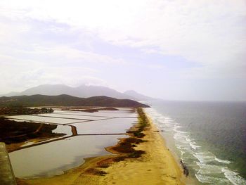 Scenic view of salt flats by sea against sky