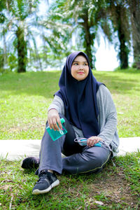 Young woman sitting on field