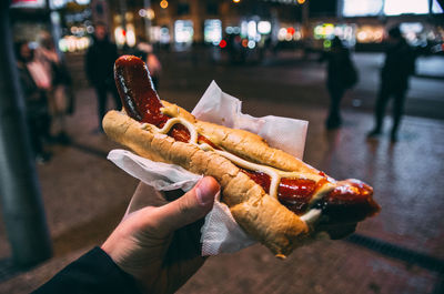 Cropped hand holding sausage