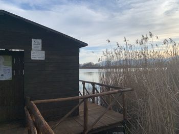 Built structure by lake against sky