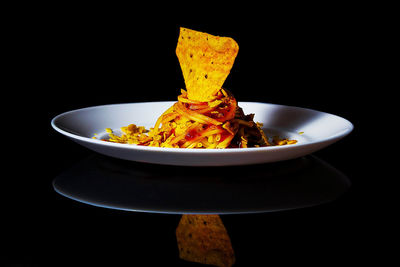 Close-up of food served on table against black background