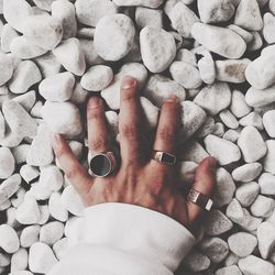 Close-up of woman hand on pebbles at beach