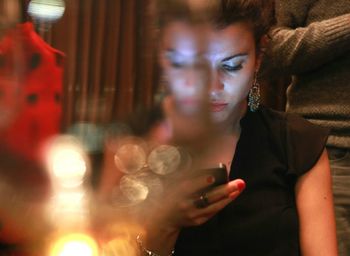 Young woman using mobile phone at restaurant