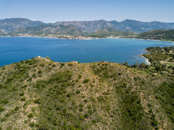 Scenic view of sea and mountains against blue sky