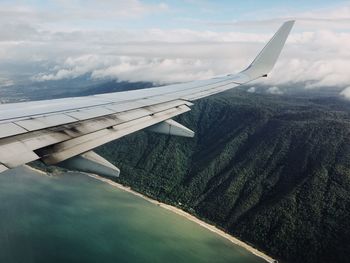 Airplane flying over landscape against sky