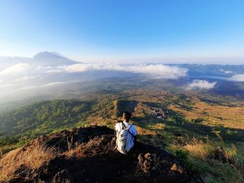 Young man looking at the view from the top of the mountain