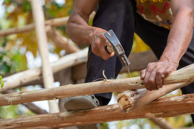 Midsection of man working on wood