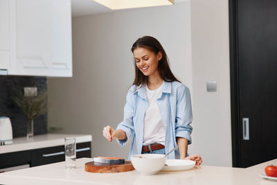 Young woman sitting on table at home