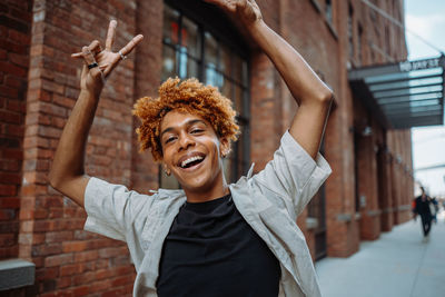 Portrait of young woman standing against wall