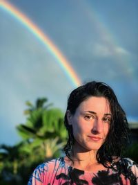 Portrait of woman standing against rainbow