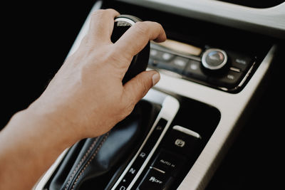 Cropped hand of man holding gearshift in car