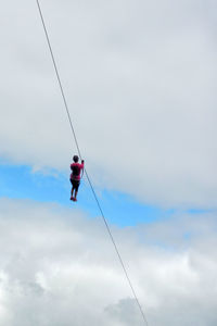 Low angle view of one person hanging on a tightrope