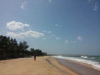 Scenic view of beach against cloudy sky