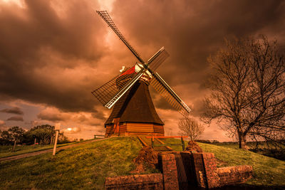 Traditional windmill on field against sky