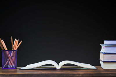 Close-up of books on table against black background