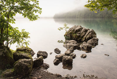 Scenic view of rocks by lake against sky