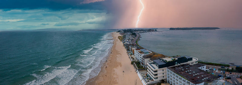 Flying over cloudy stormy beach in bournemouth, england.