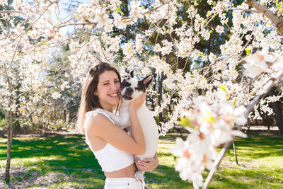 Side view of young woman holding flowers