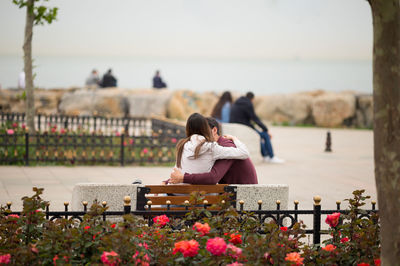 Couple embracing on bench at park