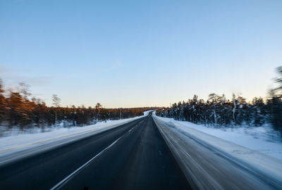 Road against clear sky during winter