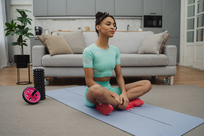 Portrait of young woman sitting on sofa at home