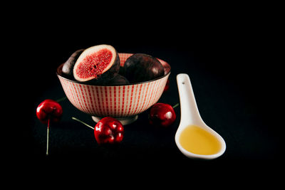 Close-up of fruits in bowl against black background