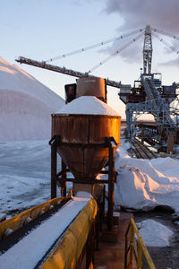 Snow covered factory against sky during winter