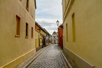 Empty alley amidst buildings in city