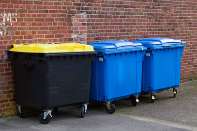 Garbage bin against brick wall