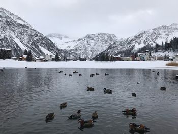 Scenic view of lake by snowcapped mountains against sky