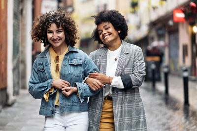 Happy young couple standing against city in background