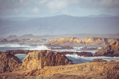 Rock formations in sea against sky