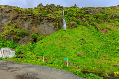 Scenic view of waterfall against sky