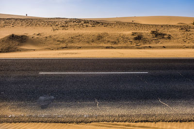 Scenic view of desert road against sky