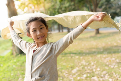 Portrait of girl holding shawl while standing at park