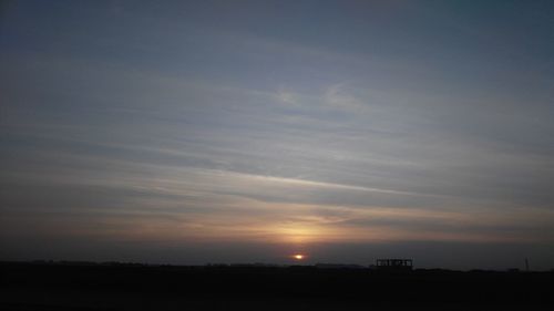 Scenic view of silhouette field against sky at sunset