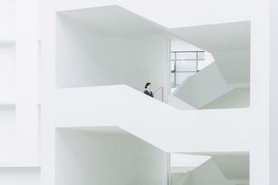 Low angle view of young woman standing in building corridor