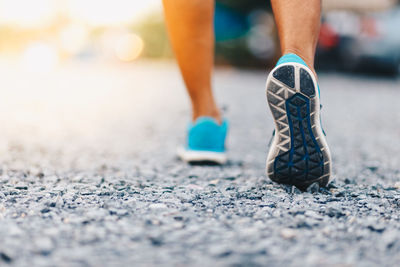 Low section of person walking on road