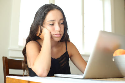 Close-up of young woman using mobile phone at home