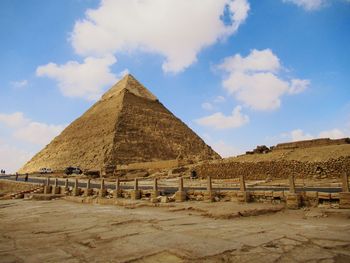 Built structure on desert against cloudy sky