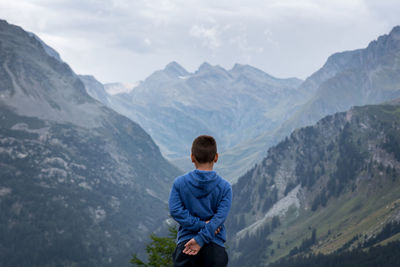 Rear view of man standing in front of mountains