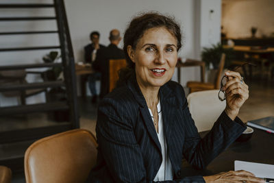 Portrait of businesswoman smiling while sitting in office