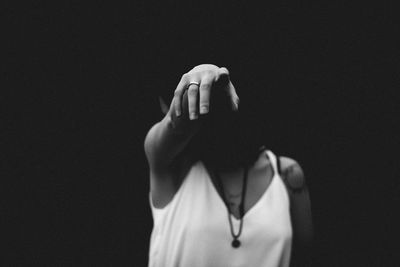 Midsection of woman standing against black background