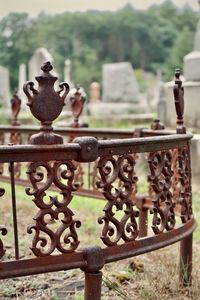 Close-up of metal railing against fence