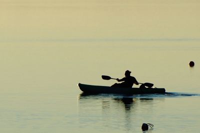 Silhouette boating at calm sea