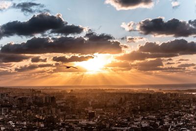 Aerial view of cityscape against cloudy sky