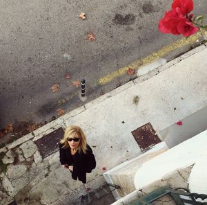High angle portrait of woman standing on sidewalk
