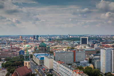 High angle view of city buildings against cloudy sky