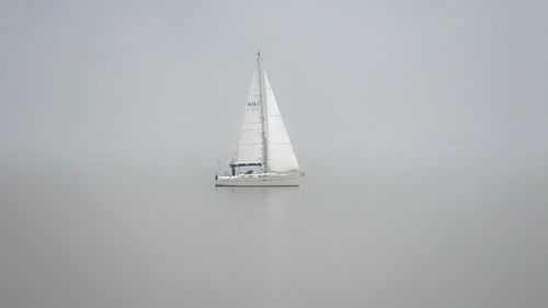 Sailboat sailing on sea against sky