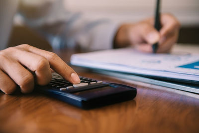 Close-up of man using mobile phone on table